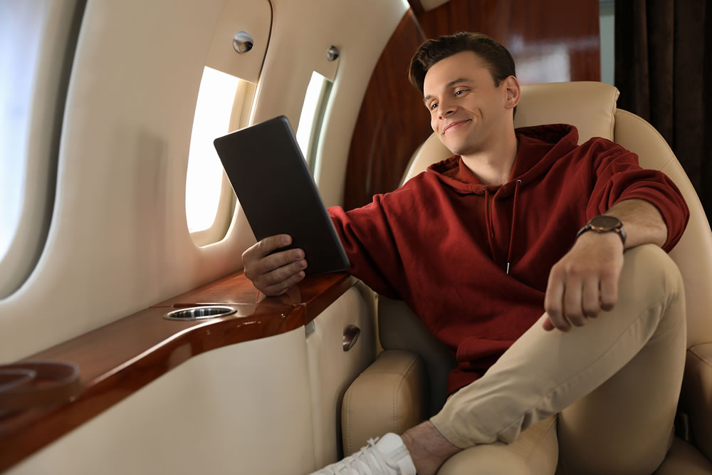 Young man using tablet in airplane during flight