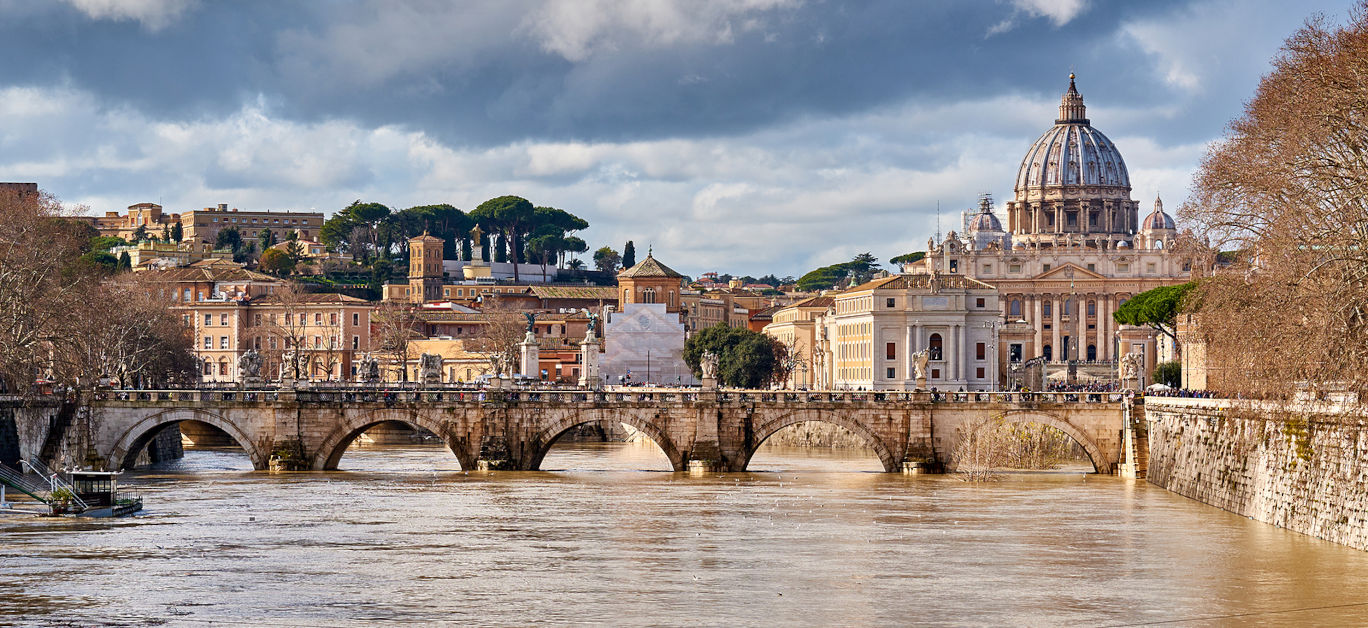 St. Peter's cathedral and Tiber river with high water in February. Saint Peter Basilica in Vatican city with Saint Angelo Bridge in Rome, Italy
