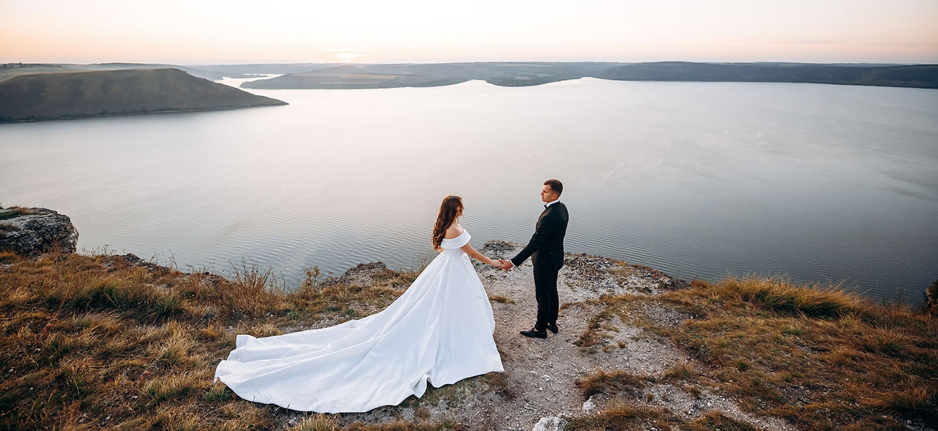 Loving wedding couple staying over beautiful landscape.