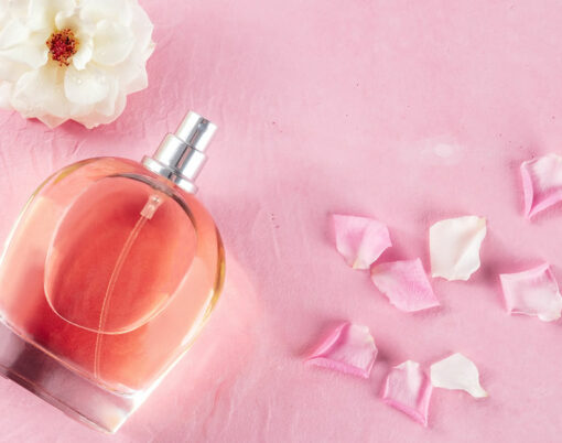Rose fragrance in an elegant bottle with fresh flowers and petals