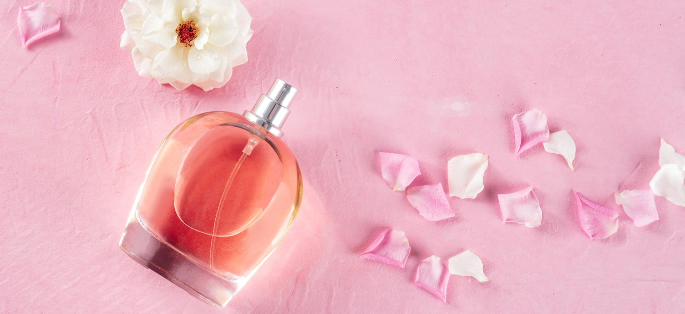 Rose fragrance in an elegant bottle with fresh flowers and petals
