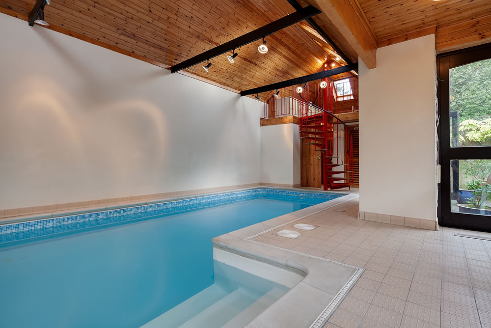 Luxury indoor house swimming pool with vaulted pine clad ceiling