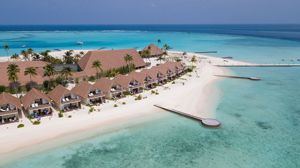 Majestic Aerial View to the Luxury Water Villas with Wooden Roofs among Clear Blue Water with no People around in the Heart of Indian Ocean - Maldivian Islands