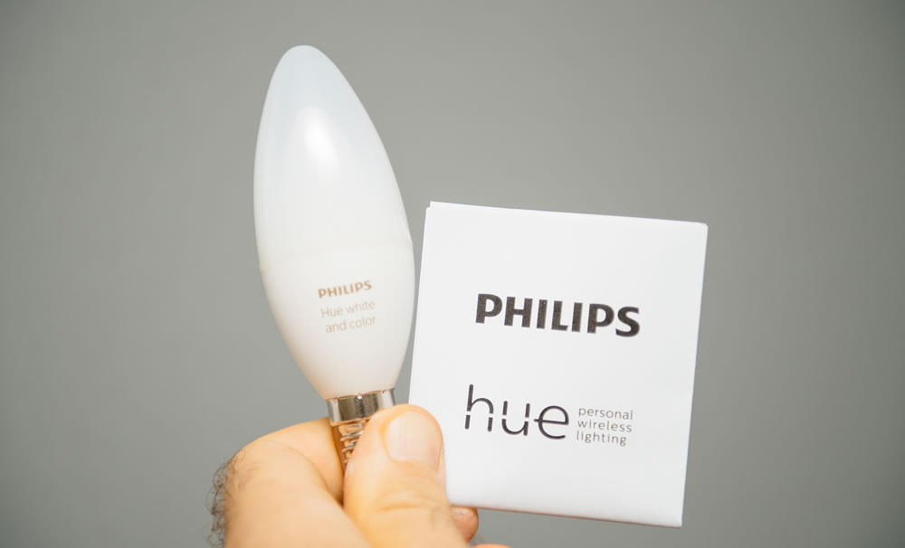 Man hand holding instruction manual and new internet connected Philips Hue E14 color and white ambiance bulb