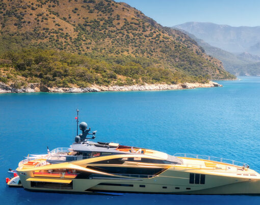 Aerial view of beautiful luxury golden yacht in blue sea