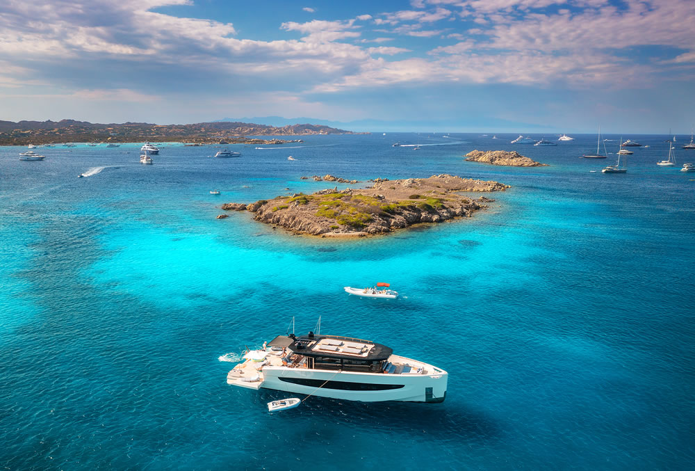 Luxury yacht on blue sea and small island at sunny day in summer