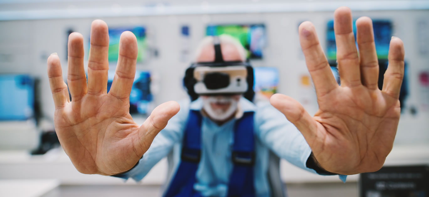 Virtual reality knocks at the door. Senior trying new virtual reality goggles.