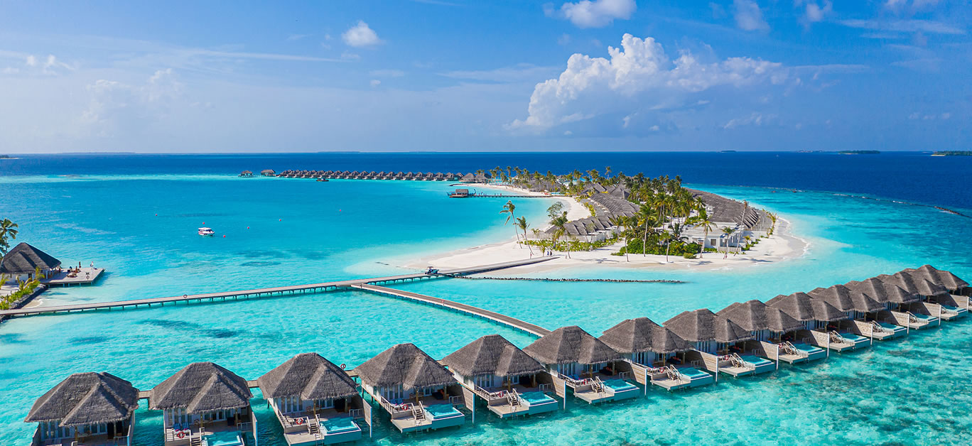Aerial view of Maldives island, luxury water villas resort and wooden pier