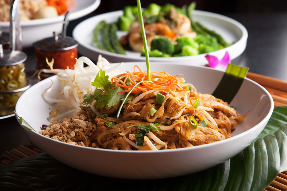 Chicken pad Thai with a variety of other fine Thai food dishes. Shallow depth of field.