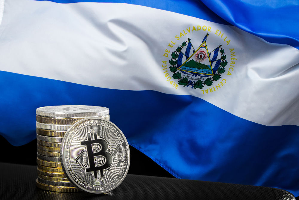 Stack of bitcoins over El Salvador flag. Bitcoin law concept.