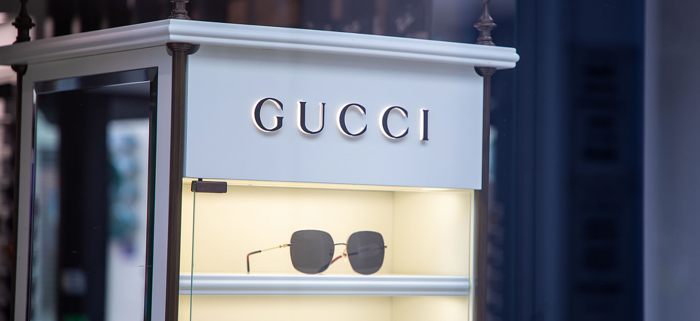 Gucci signage facade store eyeglasses entrance logo brand and text sign Italian fashion and leather goods brand