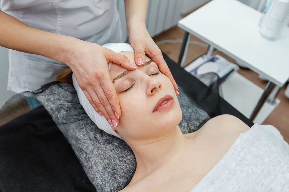 Woman under facial treatment at beauty spa