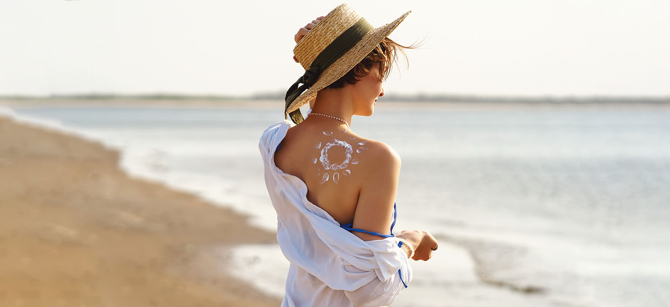 Young woman with sunscreen on back in form Sun. Skincare
