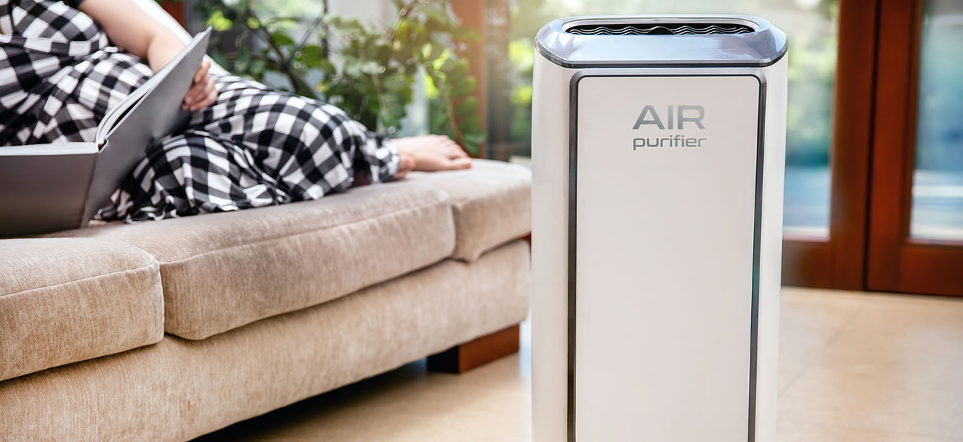 Air purifier cleans up air. Modern air purifier cleans up the air in the living room with woman lying on the couch. logo on the device was created in graphic program