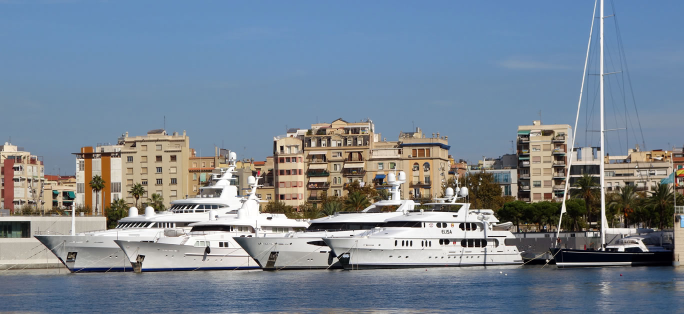 Boats and yachts parked during a hot summer noon at port of Barcelona, Spain