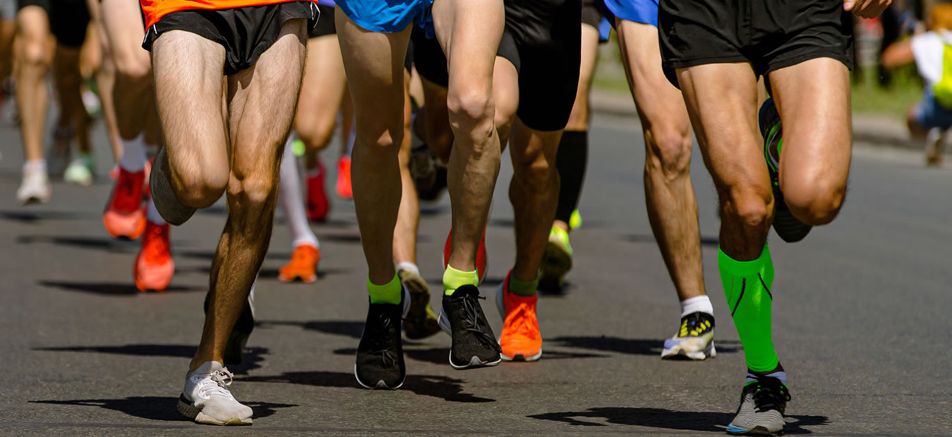 close-up legs runners running sport marathon, male jogging race in asphalt road, athletics competition