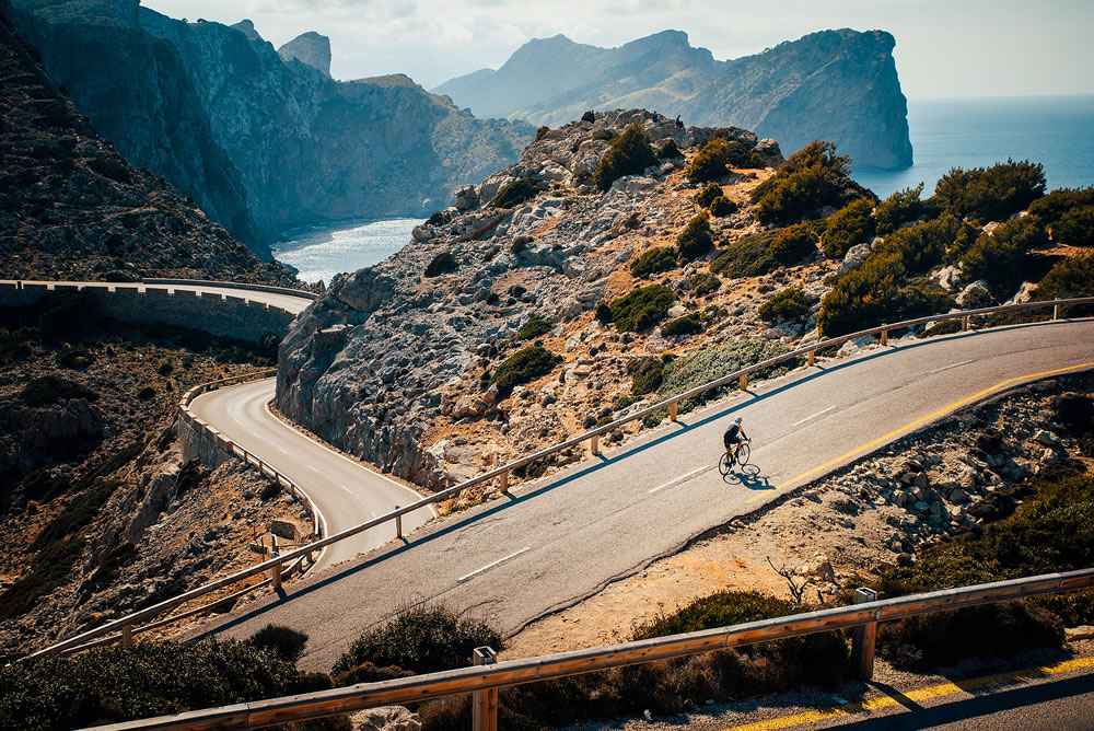 Triathlete men cycling road bike in the summer day. Beautiful nature in background. Mallorca, Majorca, Spain