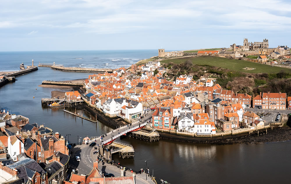 An aerial landscape of the harbour and seaside town of Whitby in North Yorkshire with Whitby Abbey prominent