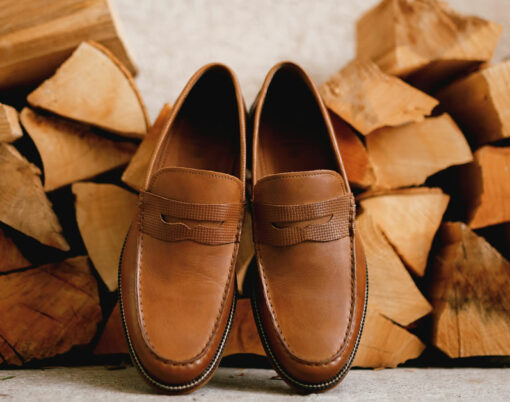 Brown mens shoes Penny loafers at the wood logs for the firebox.