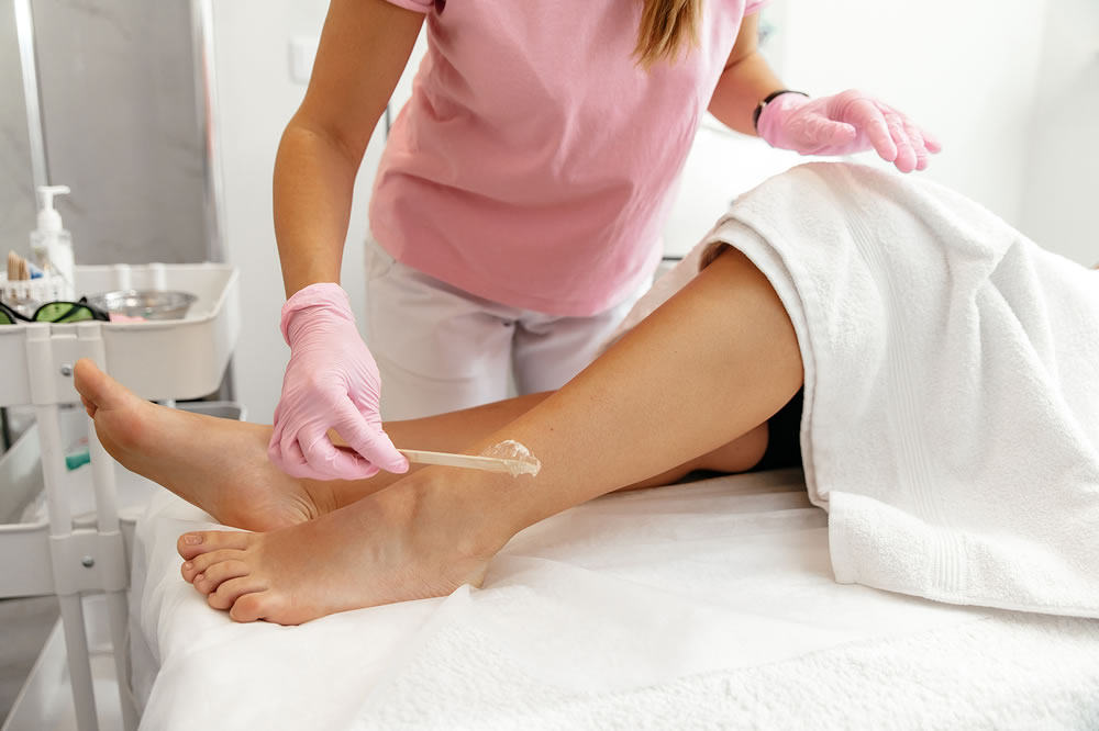 Cosmetological procedures in the salon. Application of a special gel on a womans leg before laser hair removal. Laser epilation, hair removal concept