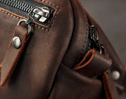 Handmade genuine brown leather on a dark background Brown belt bag. Elegant brown bag with a zipper