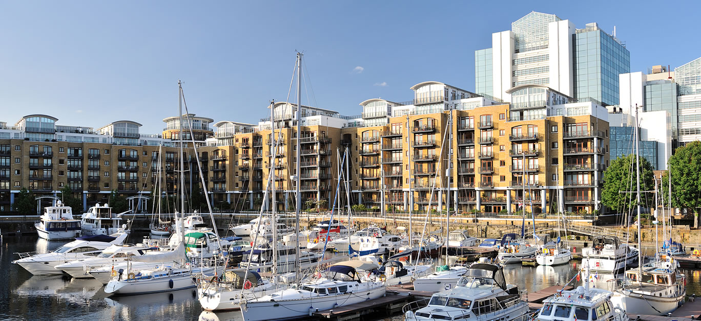 Luxury flats City Quay and yachts moored in the east dock marina St Katherine Dock London England UK Europe