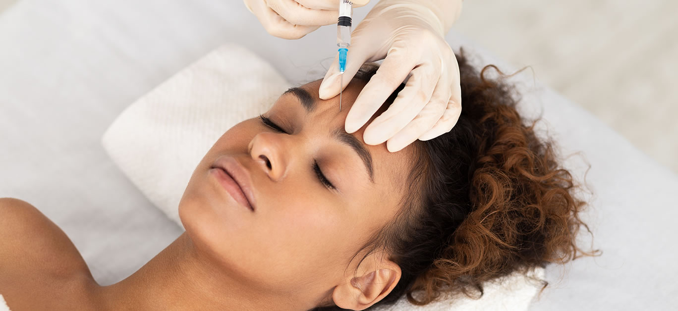 Beauty Procedure. Beautician Expert Injecting Botox In Female Forehead