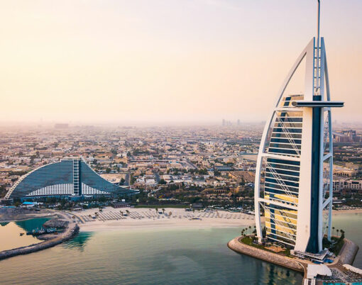Dubai seaside skyline and Burj Al Arab luxury hotel aerial view at sunrise