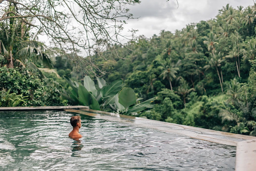 Human relaxing in Bali infinity pool with jungle view 