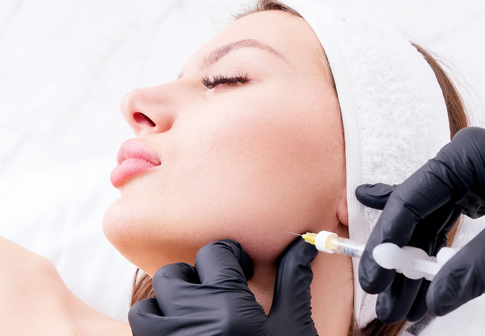 Jaw contouring or Jawline contouring facial treatment using injections to the face area. Vertical composition.