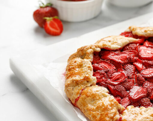 Open strawberry pie on marble board. Strawberry galette. Homemade pastry, baked cake with strawberry. Copy space, text.