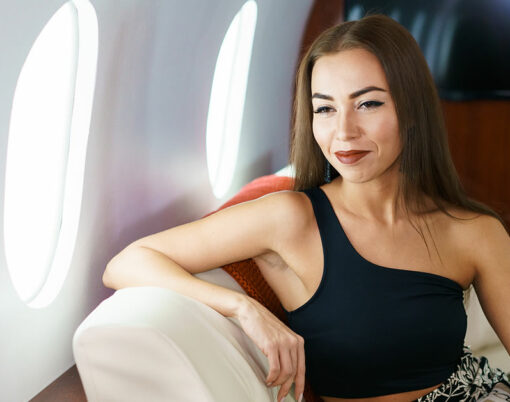 Portrait of caucasian business woman passenger on an airplane, aboard private jet. Young girl travels by plane. Travel concept