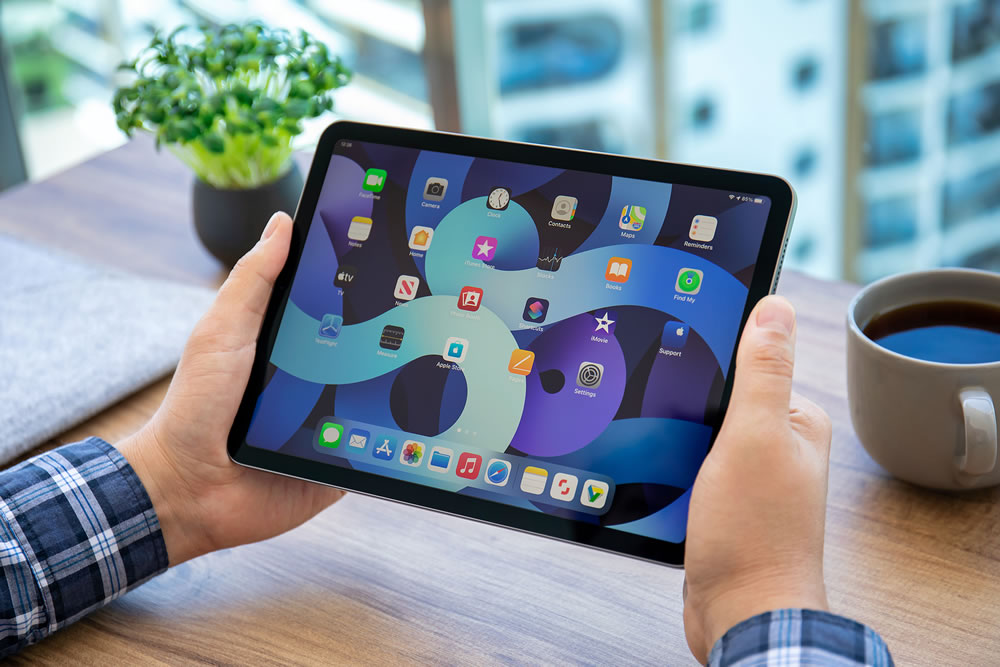 Man hand holding iPad Air IOS 14 with widget on the home screen