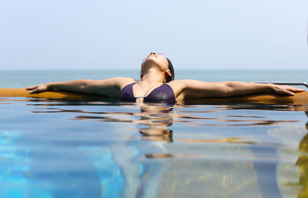 Asian woman relaxing on Spa vacation retreat in bikini in Thailand