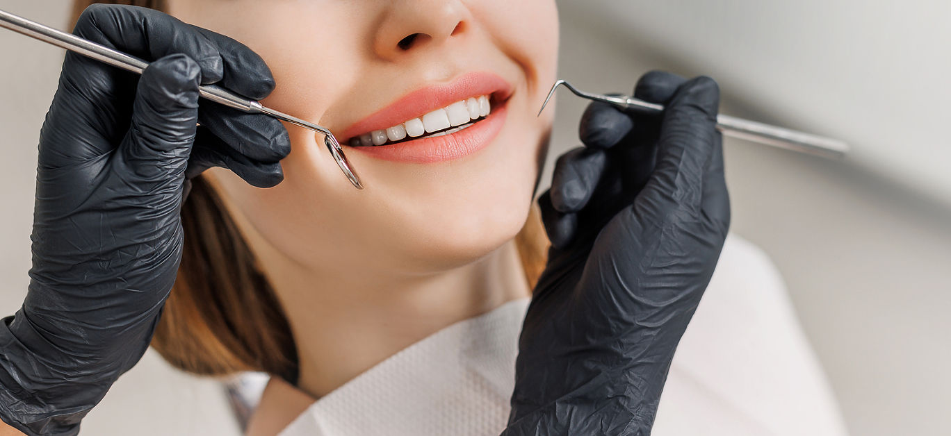 Banner for dental theme. Close-up of female smile with white teeth during medical examination. Concept of tooth whitening, treatment, veneers, professional clinic. Photo with free copy space.