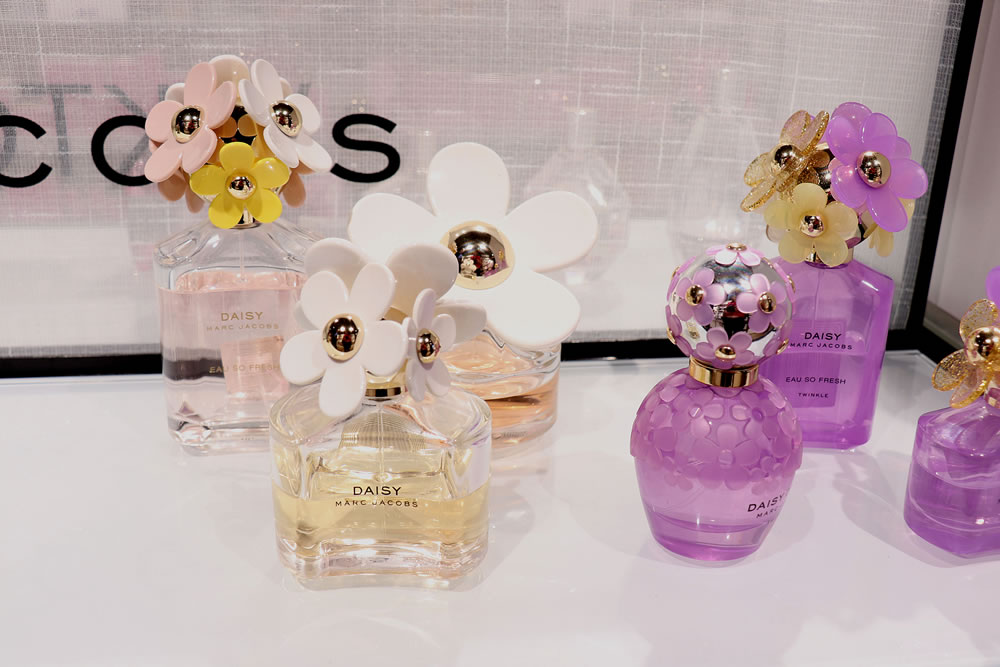 Marc Jacobs Daisy perfumes on display in a luxurious store.