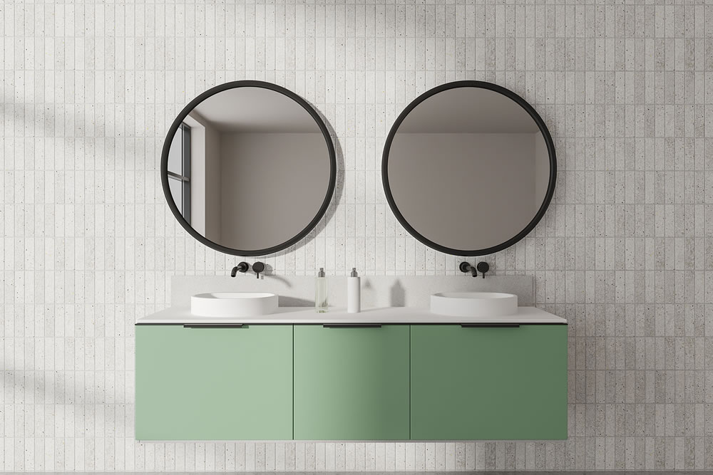 Interior of modern bathroom with white tiled walls, double sink standing on green cabinet and two round mirrors. 3d rendering