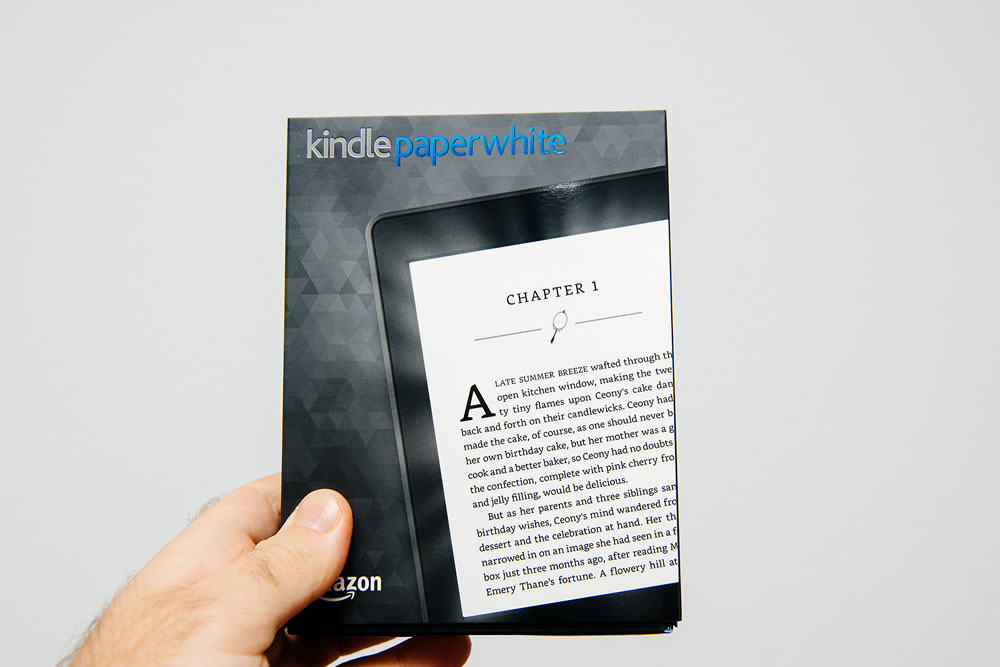 Male hand holding package of new Amazon Kindle Paperwhite package before unboxing