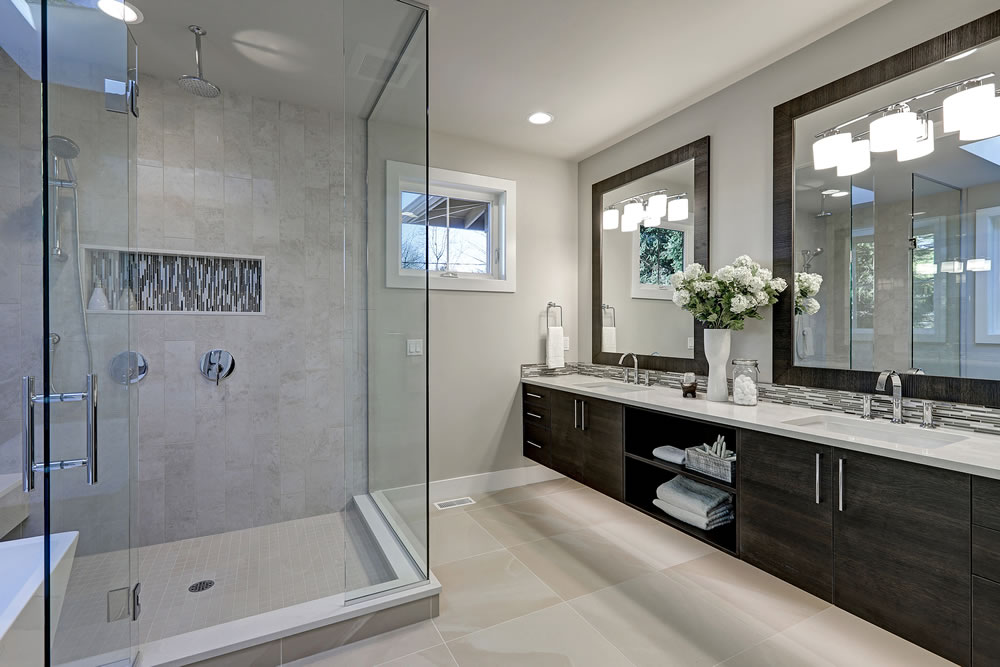 Spacious bathroom in gray tones with heated floors walk-in shower double sink vanity and skylights. Northwest USA