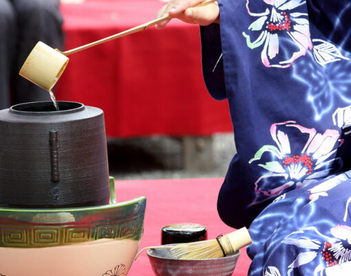 Japanese woman in traditional kimono prepares the tea ceremony