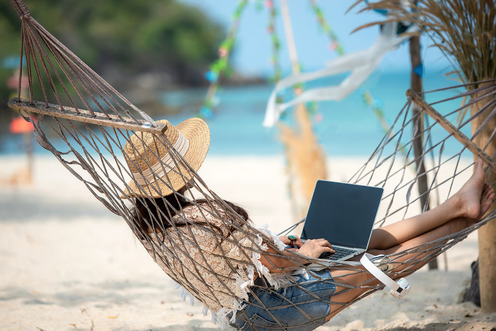 Lifestyle freelance woman using laptop working and relax on the beach.  