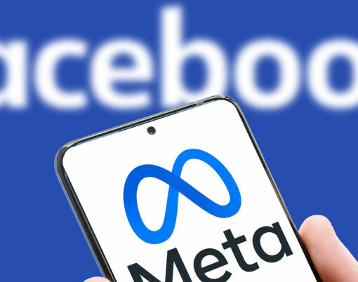 Meta logo on screen of mobile phone on Facebook word background