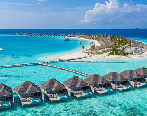 Aerial view of Maldives island, luxury water villas resort and wooden pier