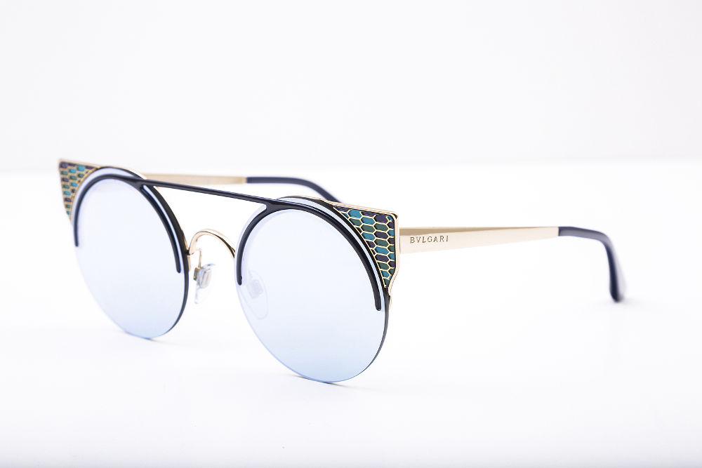 Bvlgari designer sunglasses with blue lenses on white surface