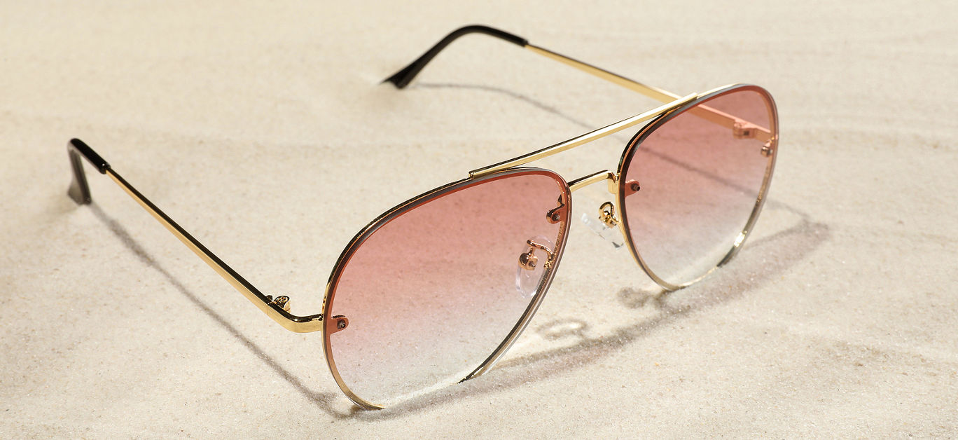 New stylish sunglasses on sand. Fashionable accessory