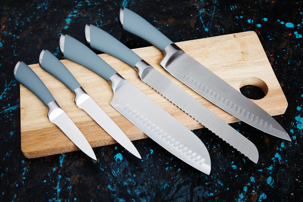 Set of five modern kitchen knives on wooden board