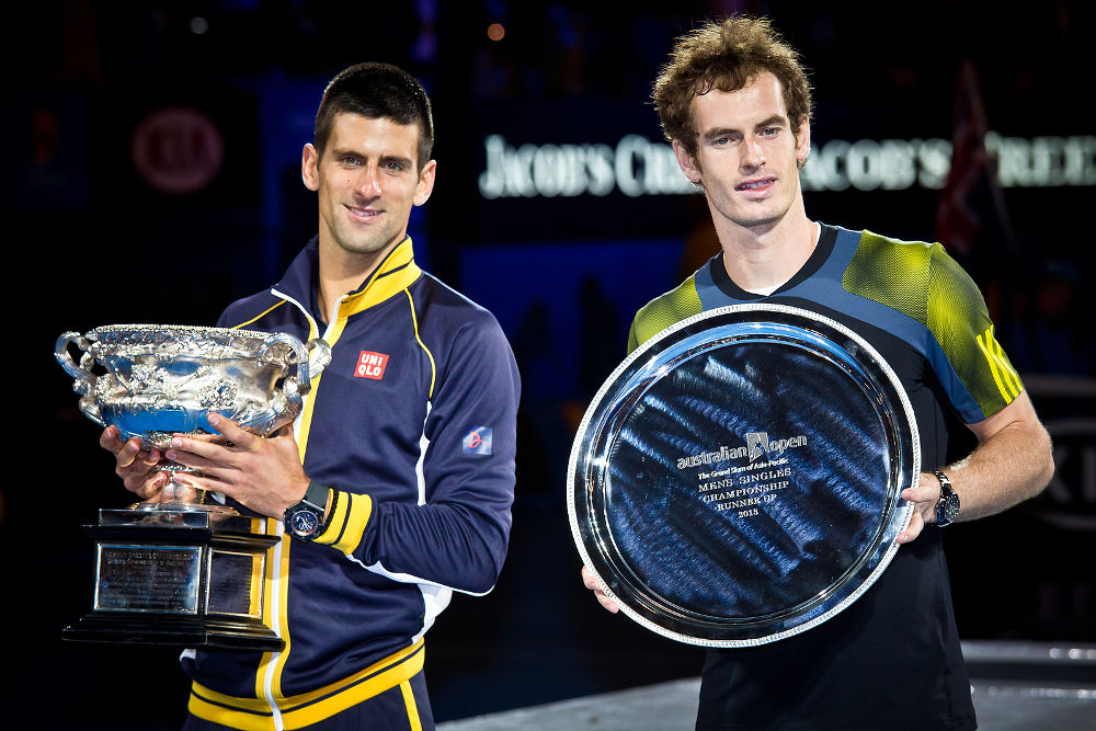 Novak Djolovic (L) of Serbia with the trophy for winning the 2013 Australian Open against Andy Murry of Scotland (R) on January27, 2013 in Melbourne, Australia.