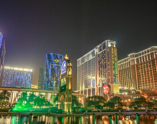 scenic view of hotels in Cotai Strip, Crown Towers, City of Dreams, Hard Rock, St Regis, Holiday Inn, Conrad, Sheraton, reflecting on The Venetian's lake in the night.