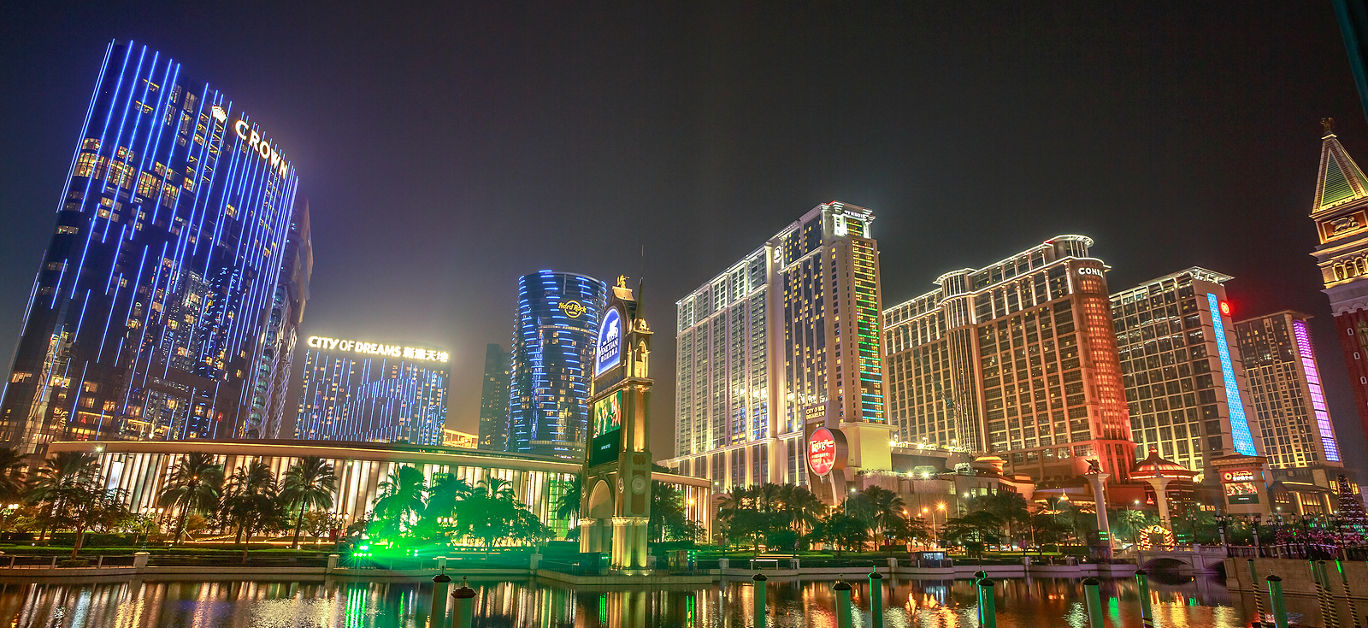 scenic view of hotels in Cotai Strip, Crown Towers, City of Dreams, Hard Rock, St Regis, Holiday Inn, Conrad, Sheraton, reflecting on The Venetian's lake in the night.