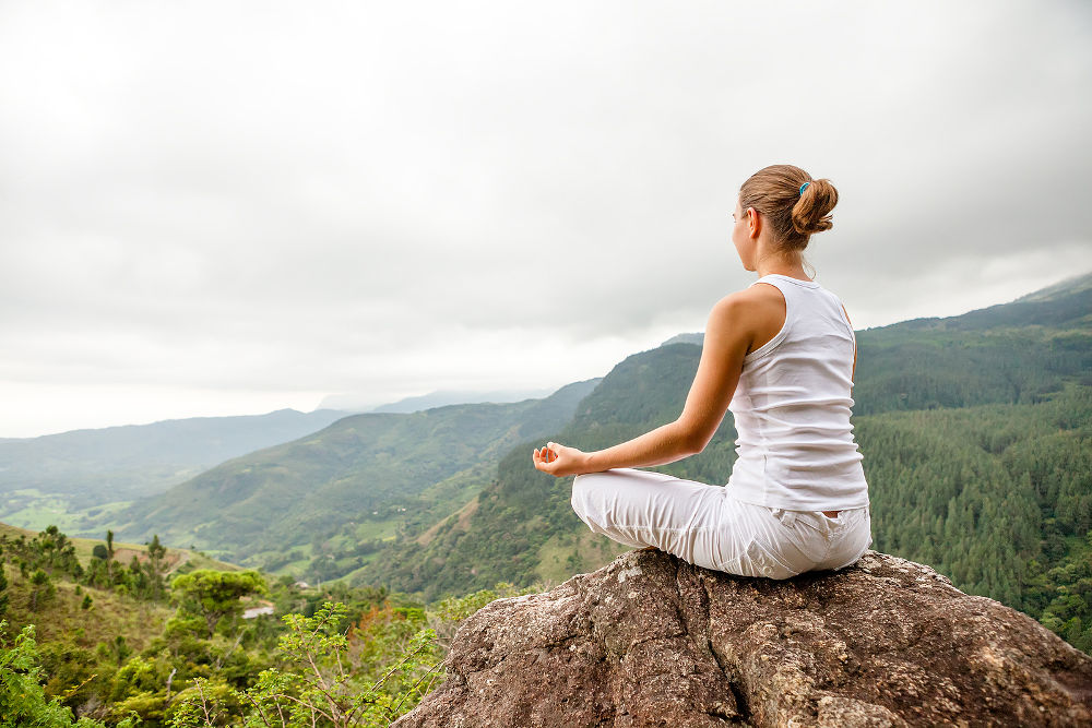 Woman is doing yoga exercises in mountains ** Note: Slight graininess, best at smaller sizes